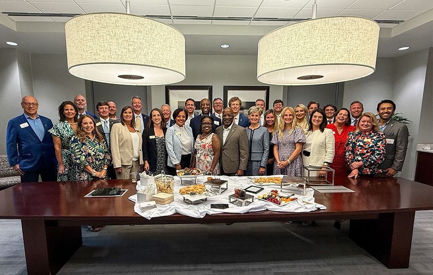 Group photo of our Charleston team and board members standing behind a conference table.