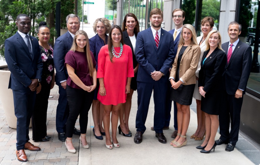 Outdoor group shot of 13 Southern First bankers on a sidewalk.