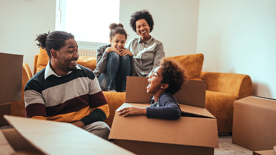 Happy family surrounded by moving boxes.