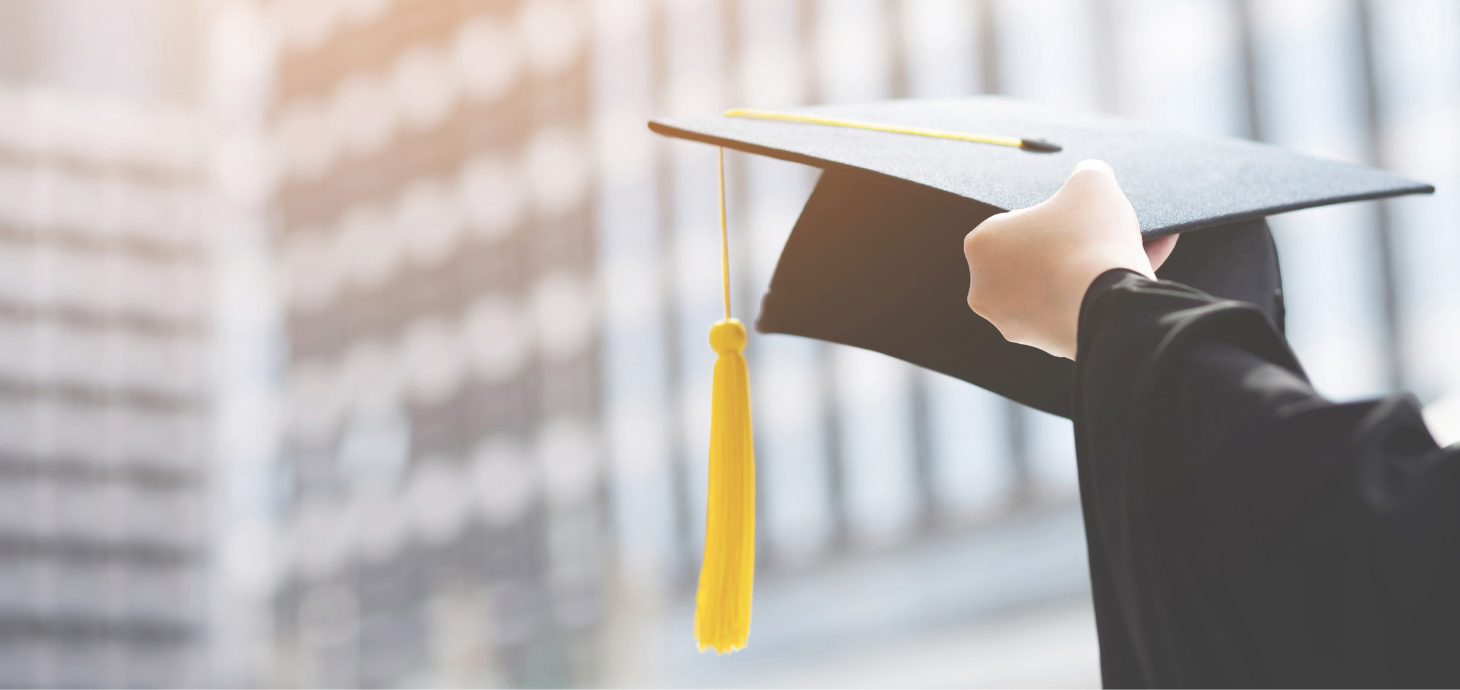 Hand holding graduation cap with tassel.