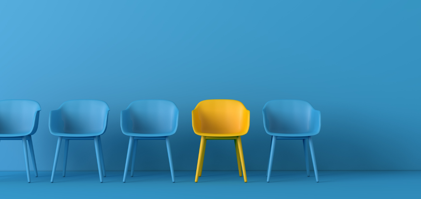 One yellow chair amidst four blue chairs on a blue background.