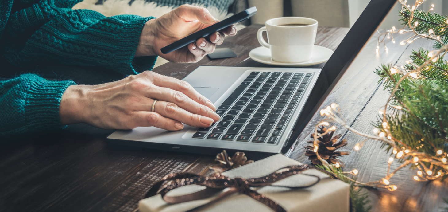 Person on laptop with credit card in hand online shopping for holiday gifts.