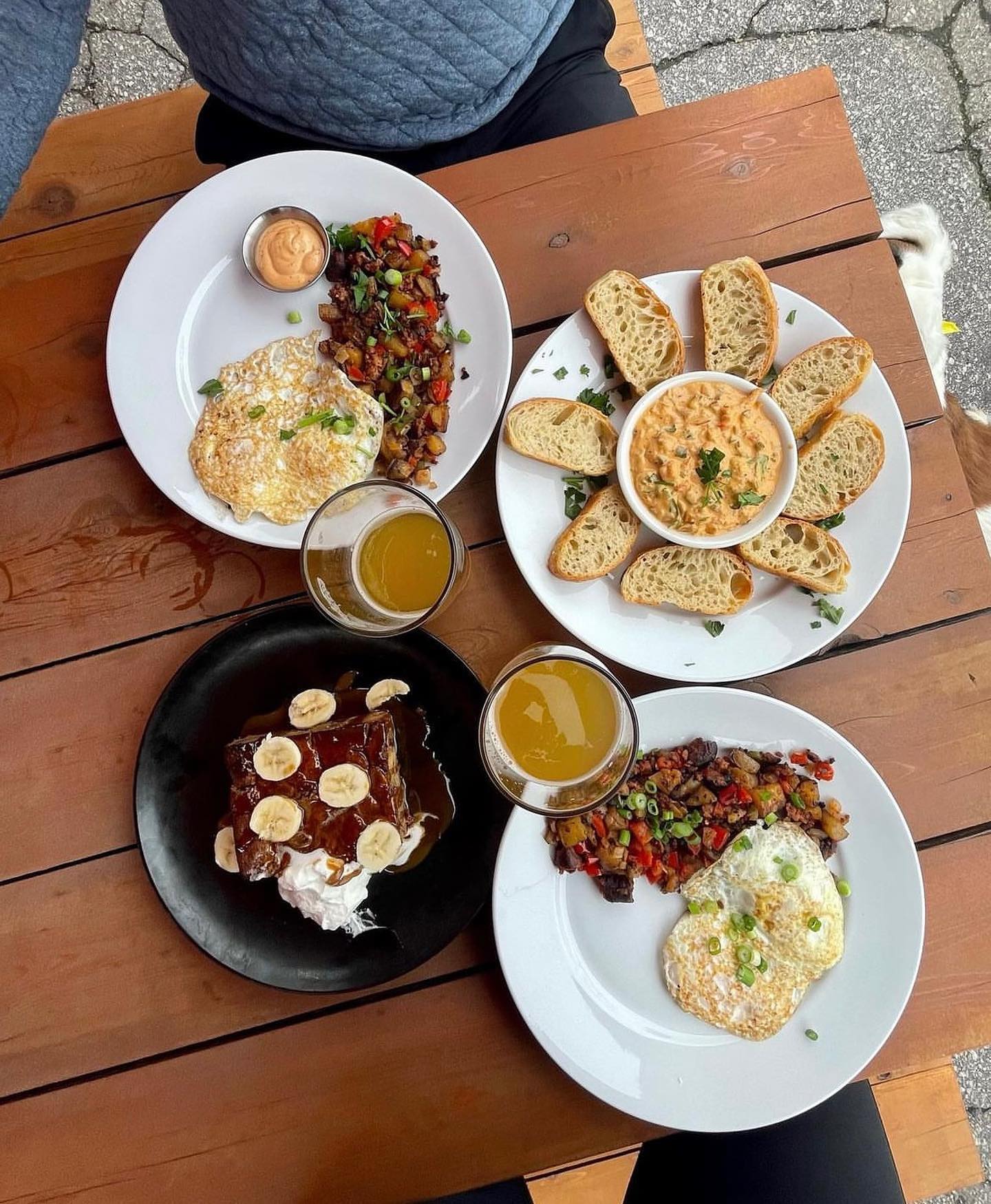 Four plates with food made by Chris Martorell on a picnic table.