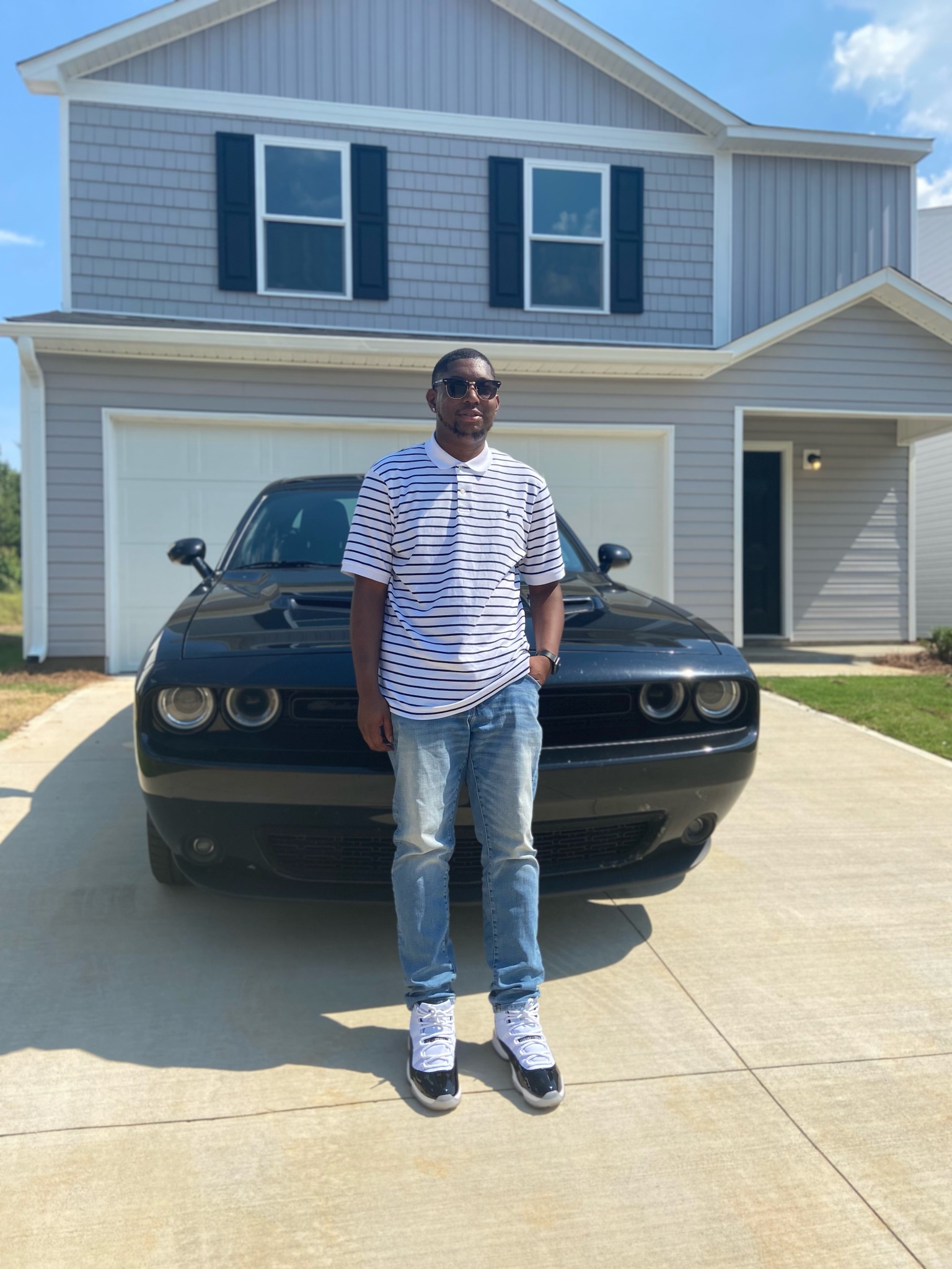 Credit Analyst, Markevius Waller, standing in front of car and first home.