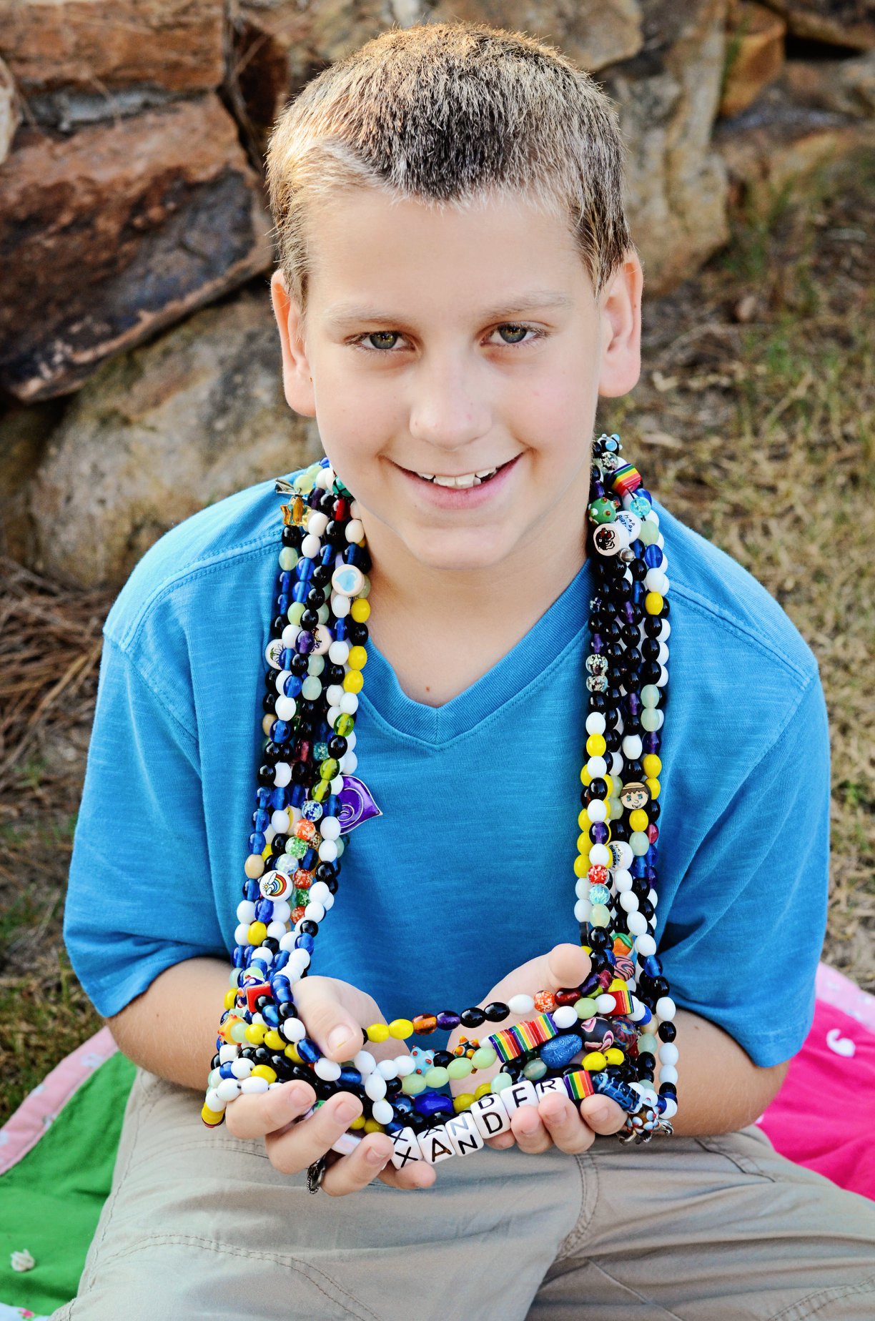 Photo of a young boy wearing beaded necklaces.