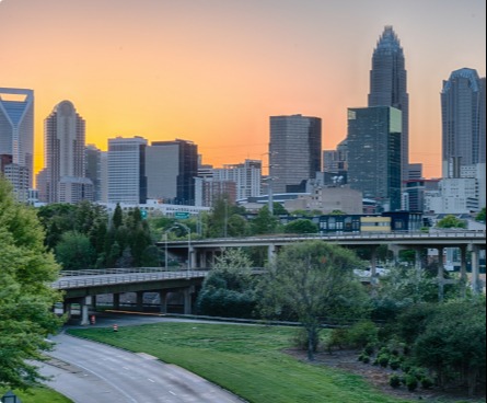 Skyline view of Charlotte from the highway at sunset.